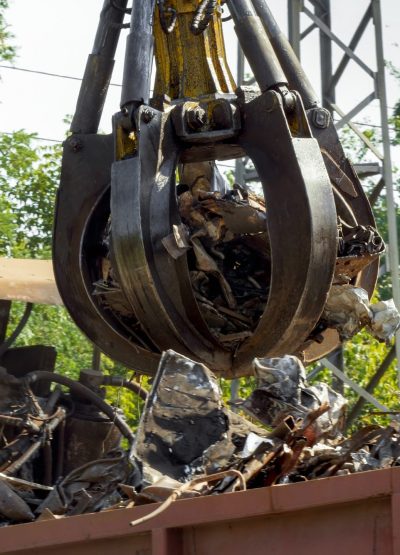 Hydraulic claw lifting and destroying metal on scrapyard